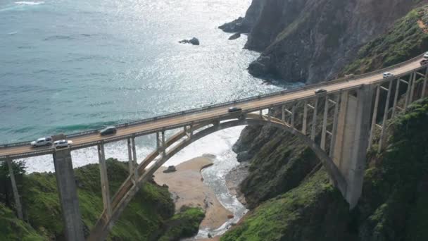 Increíble puente arqueado agraciado contra el telón de fondo de verdes colinas cubiertas de hierba. Puente de Bixby Creek. — Vídeos de Stock