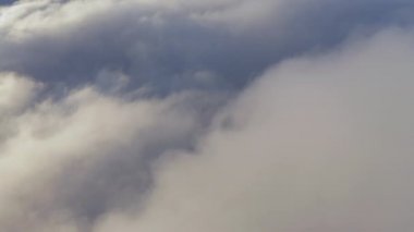 4K dairesel hava bulutların üzerinde sihirli altın sabah ışığı altında uçuyor.