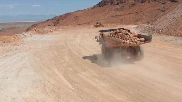 Stati Uniti. Drone segue un camion dumper caricato con le pietre rosse, la polvere sta turbinando — Video Stock