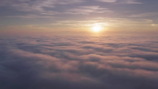 Aérien au-dessus des nuages roses au-dessus du sommet de la montagne sur le lever du soleil doré magique, USA — Video