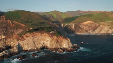 Amerika 'ya doğa yolculuğu. Gün batımında kayalık okyanus kıyısının panoramik manzarası. 4K İHA