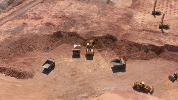 Aerial view of an excavator loading red stones into dump truck in a quarry, USA — Stock Video