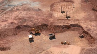 Kazıcının hava görüntüsü kırmızı taşları ABD 'deki bir taş ocağında çöp kamyonuna yüklüyor.