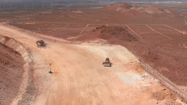 Gran sitio de negocios de la industria, EE.UU. Drone vista en un camión volquete en una carretera polvorienta — Vídeos de Stock