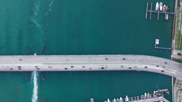 Vista de arriba hacia abajo en un puente sobre la bahía escénica. 4K aérea de carretera con tráfico — Vídeo de stock