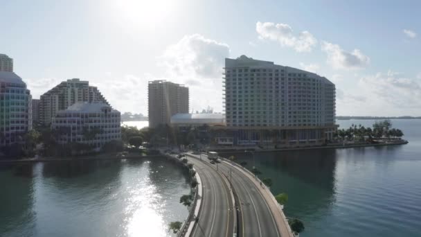 Aérea 4K de la carretera que va a los edificios residenciales. Miami en la luz de fondo — Vídeo de stock