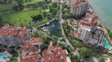 Güneşli bir günde Miami plajı ve Fisher adası üzerinde 4K hava aracı uçuşu.