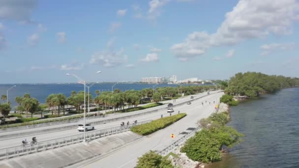 4K Miami highway вдоль морского побережья. Велосипедисты едут вдоль побережья — стоковое видео