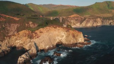 Kaliforniya sahilinin doğasında gün batımı. Manzaralı Big Sur köprüsünün panoramik görüntüsü