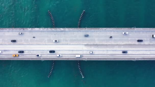 Blick von oben auf eine Brücke über die malerische Bucht. 4K-Antenne der Straße mit Verkehr — Stockvideo