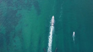 Manzaralı körfezin üzerindeki köprüden aşağı doğru. Trafikli 4K hava aracı 