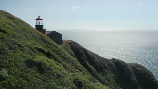 Voando sobre a ilha verde revelando o farol histórico na borda — Vídeo de Stock