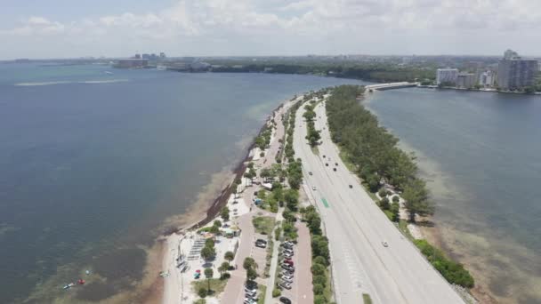 4K Miami autópálya a tengerpart mentén. Lakóépületek láthatók távolról — Stock videók