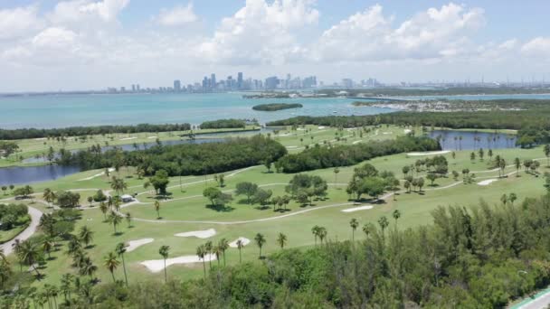 4k Luftaufnahme des grünen Golfplatzes mit Miami Downtown im Hintergrund, Florida