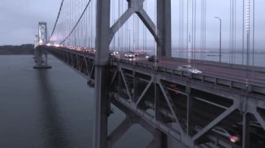 Alacakaranlıkta San Francisco körfezi üzerinde iki katlı bir yolda trafik sıkışık.