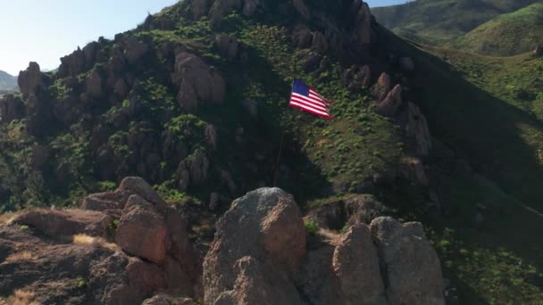 Bandera a rayas roja azul y blanca ondea en el viento en las montañas verdes escénicas — Vídeo de stock