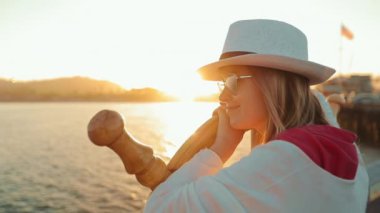 Okyanus rıhtımında huzurlu günbatımının keyfini çıkaran güzel bir kadının yakın portresi, ABD