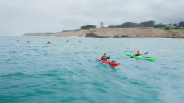 Veduta aerea degli uomini in kayak rossi e verdi che salutano gioiosamente nella fotocamera. 4K — Video Stock