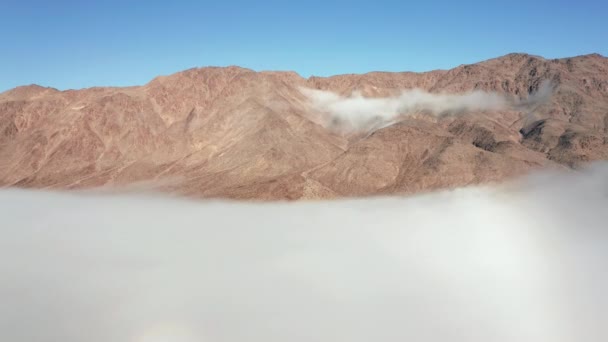 Вид з повітря на дрон, що літає над горами та білими туманними хмарами на сході сонця . — стокове відео
