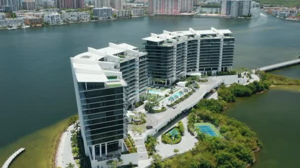 Edificio de vidrio de diseño moderno frente al mar en la isla verde en la bahía de Miami, día nublado — Vídeos de Stock