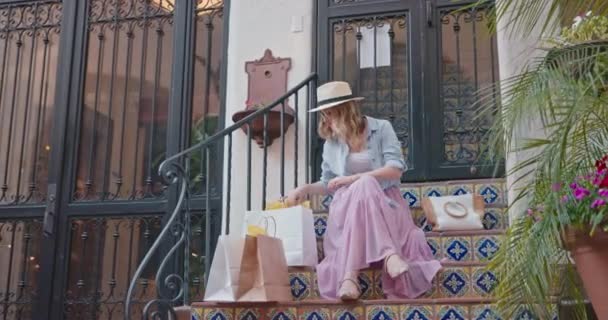 Mujer con estilo con bolsas de compras mientras se relaja en la ciudad vieja de Europa, 4K — Vídeo de stock