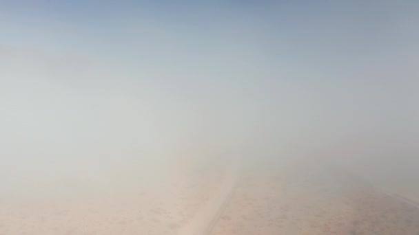 Hermoso vuelo a través de la espesa nube de niebla al amanecer. Fondo del desierto — Vídeos de Stock