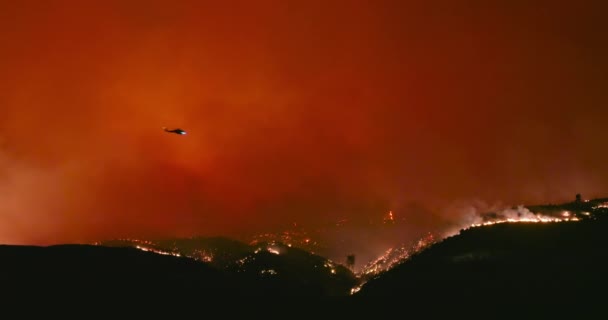 野火の上を飛ぶヘリコプターの壮大なショット。オレンジと赤の炎のプルーム — ストック動画