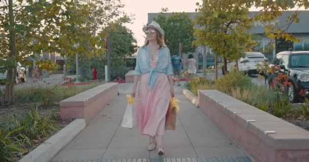 Mujer con bolsas de compras caminando en el centro comercial al aire libre después de COVID-19, 4K — Vídeos de Stock