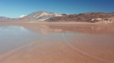 Çölün ıslak yüzeyinde yarış pisti olan taştan inen destansı bir hızla.