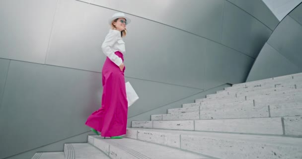 Modische Frau, die nach dem Einkaufen mit Taschen die Treppe hochgeht, 4K — Stockvideo