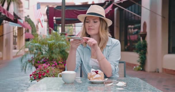 유럽에서 휴가를 보내는 동안 미소짓는 여자가 거리 식당에서 휴식을 취하는 모습 — 비디오