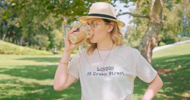 Mujer bonita caucásica se encuentra en el parque verde con excelentes vistas a la naturaleza al aire libre — Vídeo de stock