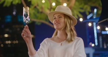 Şampanya içen, kadeh kaldıran, romantik bir geceyi kutlayan bir kadın.