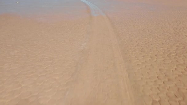 Voando baixo perto da superfície molhada do deserto rachado e da pista de corrida de pedra — Vídeo de Stock
