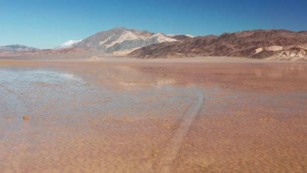Тяжелые загадки движущихся камней на влажной трещины поверхности Долины Смерти, 4K воздушных — стоковое видео
