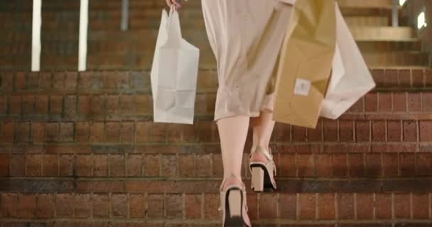 Sacs shopping 4K au ralenti. Femme portant des talons à la mode monter les escaliers — Video