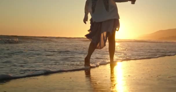 Cerca de los pies de la mujer caminando descalzo por la playa en la luz dorada del atardecer — Vídeos de Stock