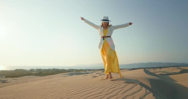Zpomalte pohyb krásné ženy tančící v poušti. Stylová dívka se baví při západu slunce — Stock video