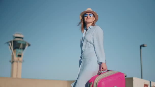 Al rallentatore di un viaggiatore donna. Torre di dispacciamento dell'aeroporto sullo sfondo al tramonto — Video Stock