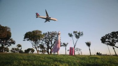 Mutlu gezgin gün batımında parkta dans ediyor. Yavaş çekim yaz tatili