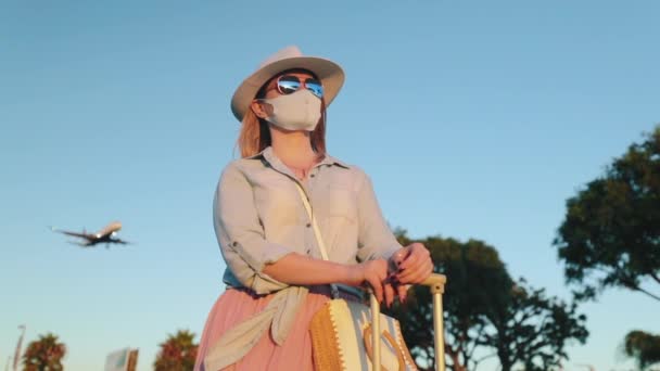 Safe travels under COVID-19. Summer vacation 2020. Woman in face mask at sunset — Stock Video