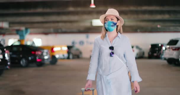 Bezpieczne podróże pod COVID-19 stylowy podróżnik w kolorowe maski na lotnisku parking — Wideo stockowe