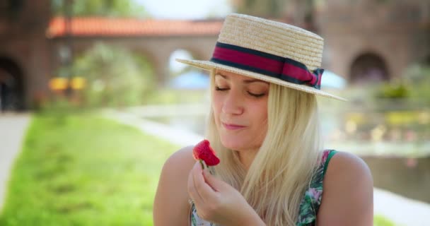 Attractive woman eating strawberry. People and food concept slow motion footage — Stock Video