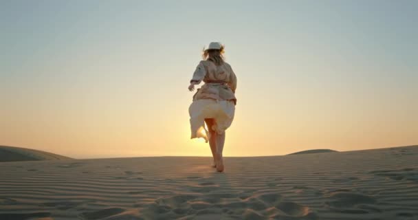 風光明媚な砂漠の自然景観で夕日に向かって走る女｜4Kスローモーション — ストック動画