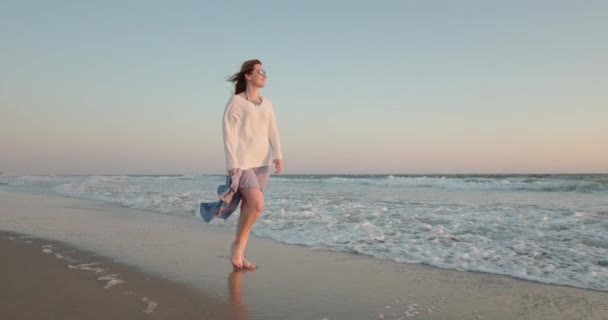 Attraktiv kvinna i vågig klänning promenader barfota vid Stilla havet strand, slow motion — Stockvideo