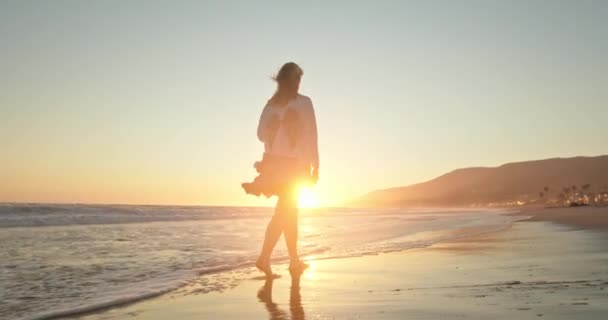 Inspirerande slow motion-film med ung resenär promenader vid stranden vid solnedgången — Stockvideo