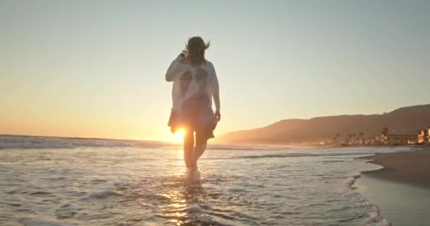 Cinematic slow motion attraktiv kvinna njuter av vacker gyllene solnedgång — Stockvideo