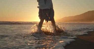 Ağır çekim: kadın okyanusta yürüyor dalgalarda hayatın ve özgürlüğün tadını çıkarıyor.