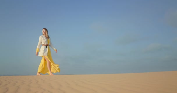 Espaço azul para cópia ou texto no fundo com mulher andando por areia ondulada — Vídeo de Stock