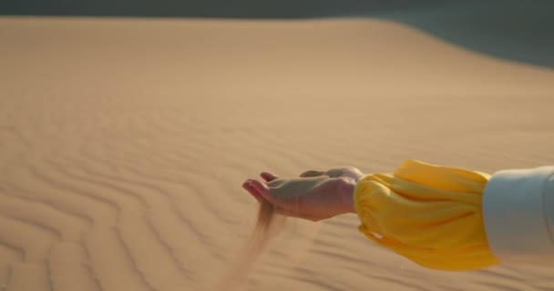 Жінка хапає жменьку сухого піску і дозволяє йому впасти між пальцями, 4K — стокове відео